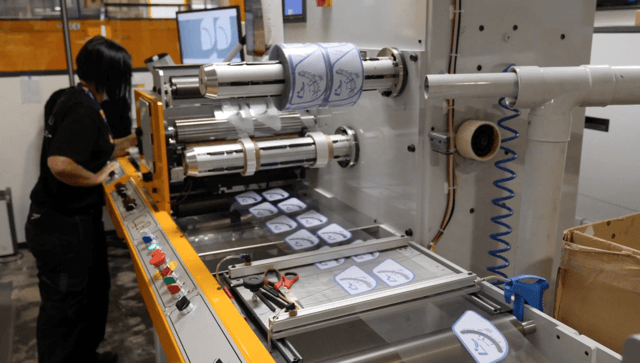 Image of person managing labels on machine