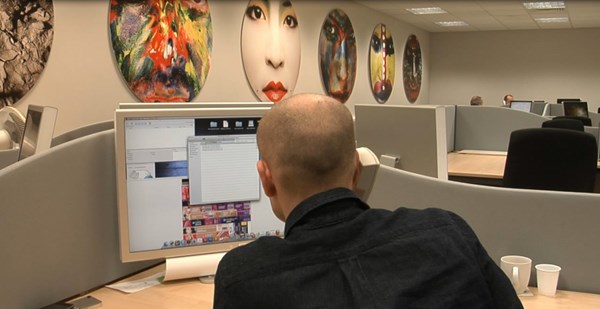 Image of Data Image Group Ltd employee looking at Prepress system on computer monitor